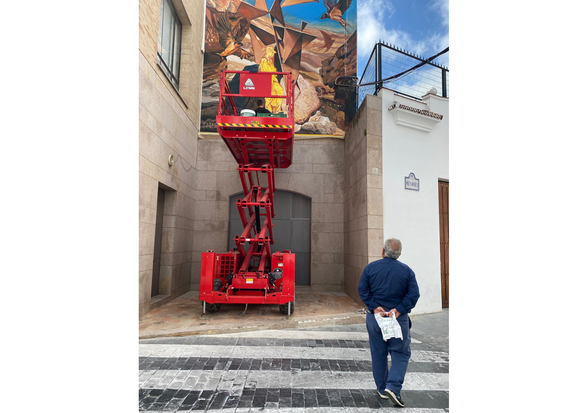 fresque murale réalisée en Espagne à Baena qui représente un personnage dans un paysage rocailleux surréaliste et entouré d'oiseaux.